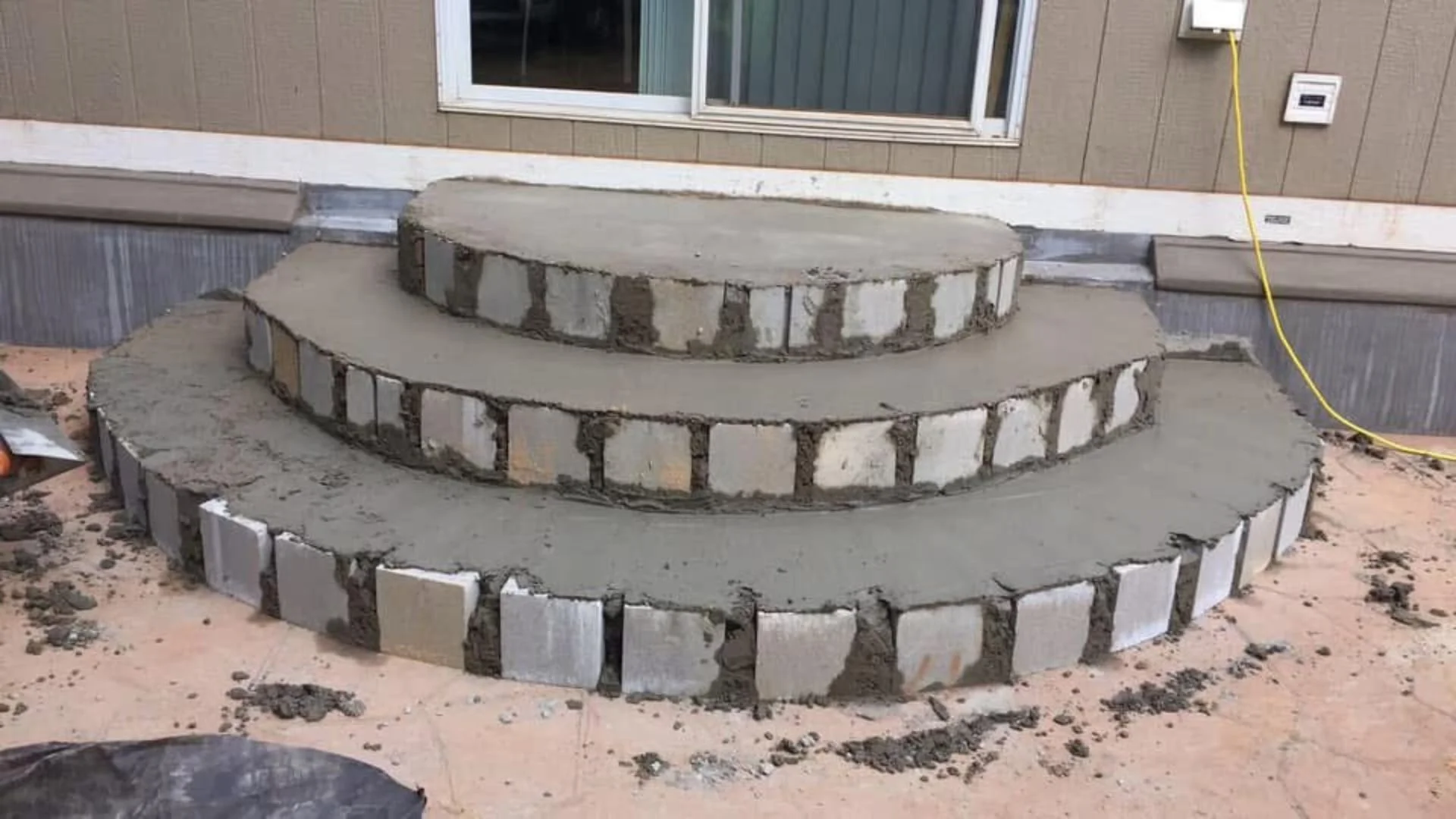 Curved concrete steps under construction with stone masonry finish – complete exterior restoration project by ABC Masonry